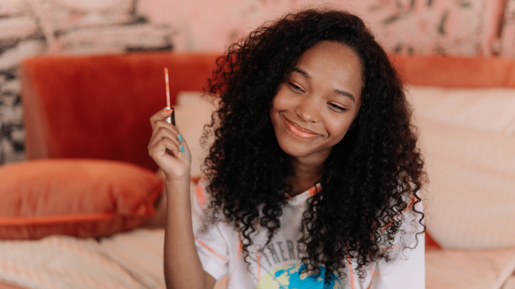 Girl smiling holding glossier product