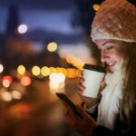 Woman on her phone with coffee.