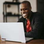 Man Smiling While Working on Laptop